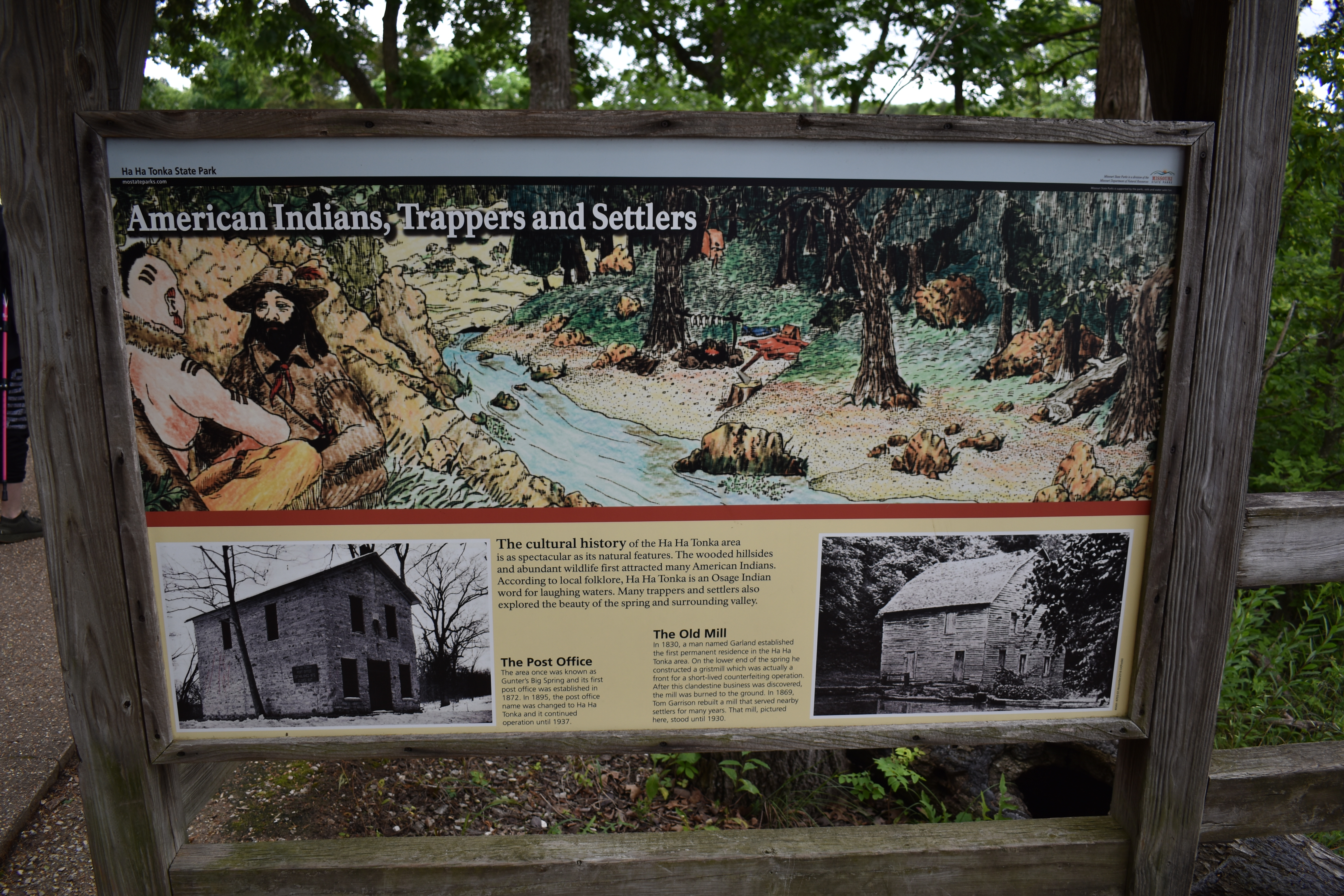 Informational sign with history of Ha Ha Tonka Castle Ruins and stone walls